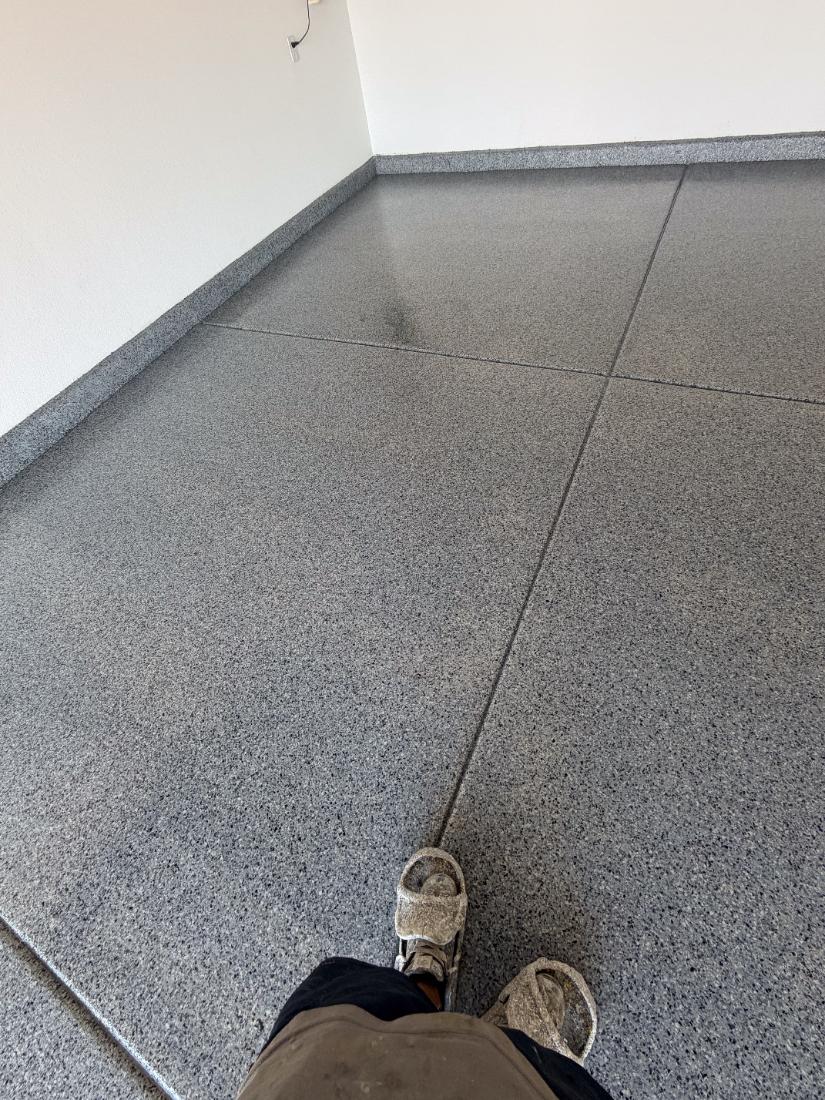 Bare concrete garage floor being diamond ground before epoxy coating by Tabwa Coatings