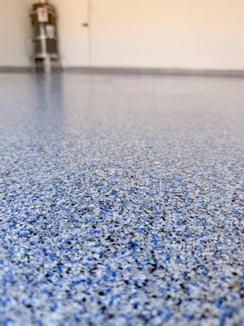 Close-up of blue flake epoxy floor chips and clear topcoat by Tabwa Coatings